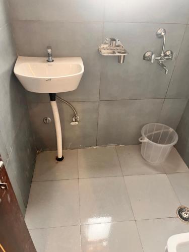 a bathroom with a sink and a trash can at Apna Homes Stay & Hotel I Gurugram I Sector-71 in Gurgaon