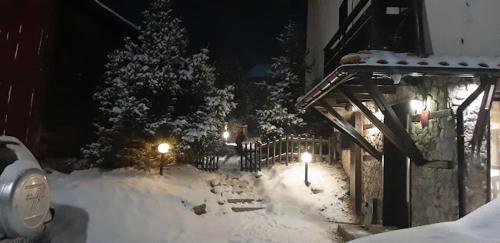 a yard covered in snow at night with lights at Guest House Raffe in Dobrinishte