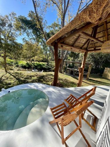 a swimming pool with two chairs and a table at Hot spring tiny home in Limpopo in Gemsbokfontein