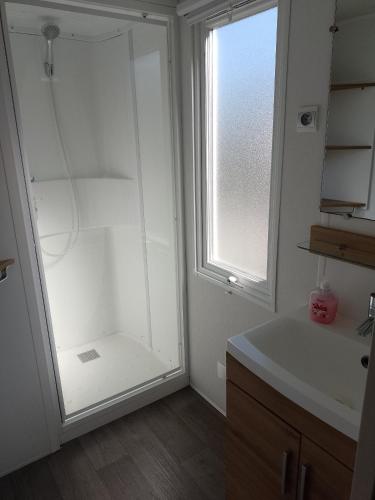 une salle de bain avec une douche et un lavabo et une fenêtre dans l'établissement MHVACANCES 2 LOUENT PLUSIEURS MOBILHOMES DANS CAMPING 4 ETOILES PROCHE CHATEAUX et ZOO BEAUVAL, à Onzain