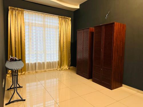 a living room with a large window and a table at MutiaraMaxx Homestay in Kampong Jelatang