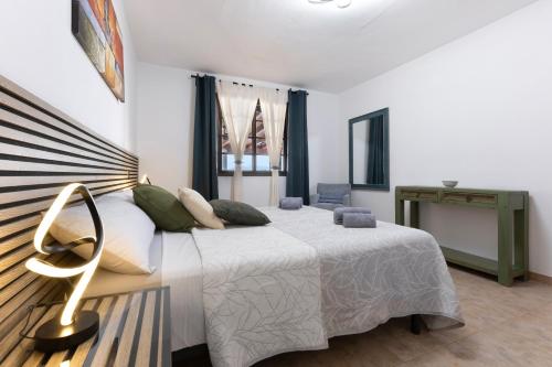 a bedroom with a large white bed with green pillows at Las Catalinas in Gran Tarajal