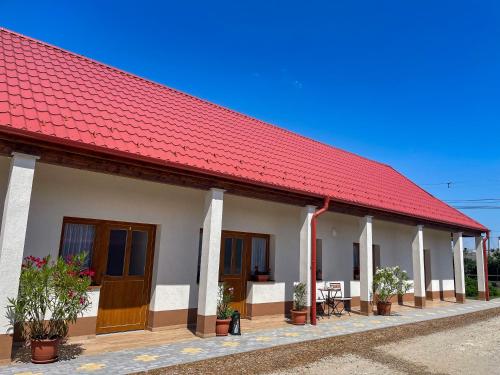 a building with a red roof and some plants at Csorgó Vendégház in Felsődobsza