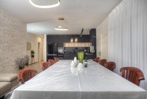 a dining room with a large white table and chairs at אחוזה בהרים in Meron