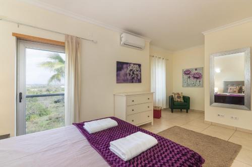 a bedroom with a bed and a large window at Jardins Vale de Santa Maria, with pool in Albufeira