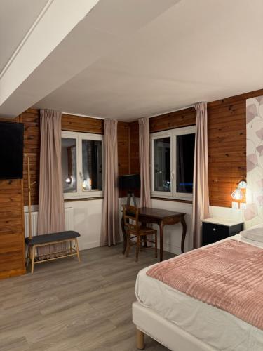 une chambre avec un lit, un bureau et une table dans l'établissement Le Napoléon, à Corps