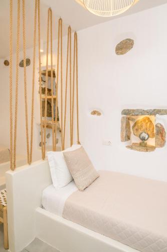 a white room with a bed and a chandelier at Idothea guest house in Amorgos