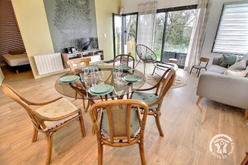 une salle à manger avec une table et des chaises en verre dans l'établissement Des contrebandiers, à Saint-Cast-le-Guildo