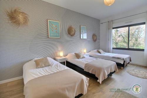 Un dormitorio con dos camas y una ventana. en Des contrebandiers, en Saint-Cast-le-Guildo