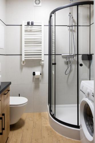 a bathroom with a shower and a toilet and a sink at Sekwoja Rent - Malmeda 15 in Białystok