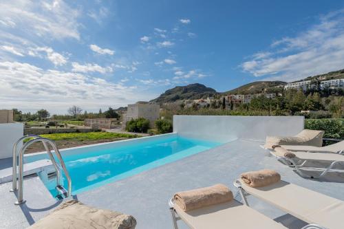 a villa with a swimming pool with a view at Mythos villas in Damnoni