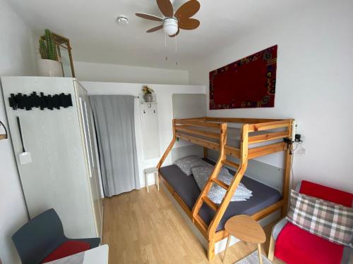 a room with a bunk bed and a ceiling fan at Ferienwohnung Tiny-Klotzsche in Dresden
