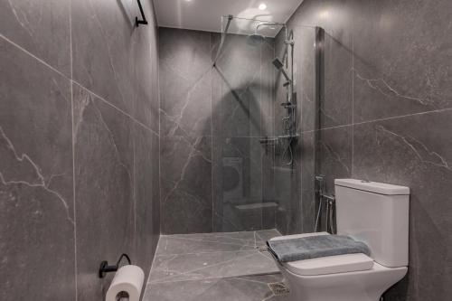 a bathroom with a shower and a toilet in it at Mythos villas in Damnoni