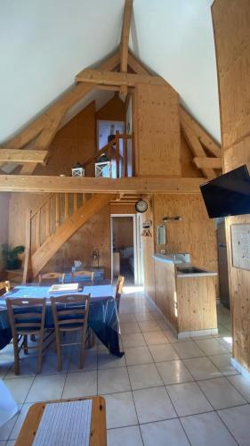 une grande chambre avec des tables et des chaises dans un bâtiment dans l'établissement Cottage 19 Bulle Der jusque 8 Personnes vue Lac du Der, à Giffaumont