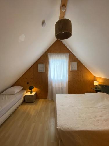 une chambre avec un lit blanc et une fenêtre dans l'établissement Cottage 19 Bulle Der jusque 8 Personnes vue Lac du Der, à Giffaumont