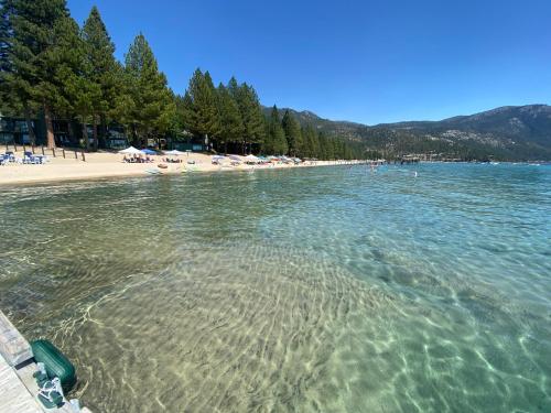 a beach with chairs and umbrellas in the water at Experience the Beauty of Tahoe from Your Zephyr Cove Retreat! #2 in Zephyr Cove