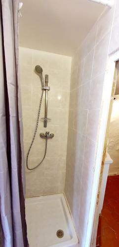 une douche avec pommeau de douche dans une salle de bain dans l'établissement Appartement spacieux & familial., à Cotignac