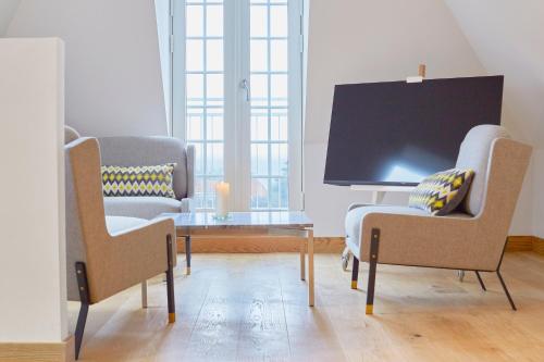 a living room with two chairs and a table at Hôtel de Ville in Gilleleje