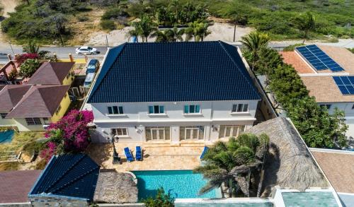 an aerial view of a house with solar panels on its roof at La Casa Piu Bella where the customer is king in Palm-Eagle Beach