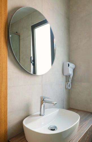 a bathroom with a white sink and a mirror at Margo Beach Hotel in Gythio