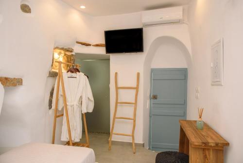 a room with a bed and a tv on a wall at Idothea guest house in Amorgos