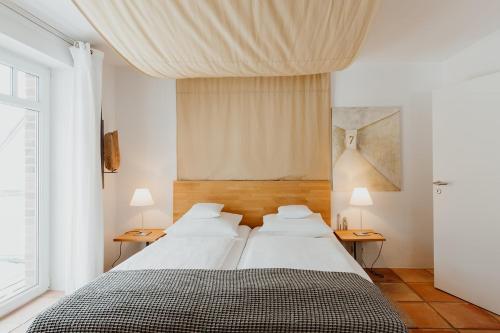 a bedroom with two beds and two tables with lamps at Quartier Carpe Diem in Prerow