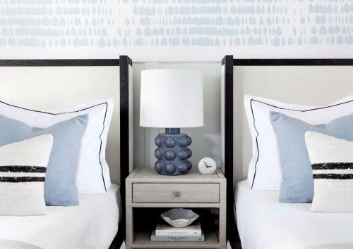 a bedroom with two beds and a lamp on a night stand at Wequassett Resort and Golf Club in East Harwich