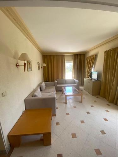 a living room with a couch and a table at Hôtel Green Golf Hammamet in Hammamet