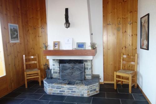 a living room with a fireplace and two chairs at Fontannets 003 MOUNTAIN & QUIET chalet 10 pers in Salins