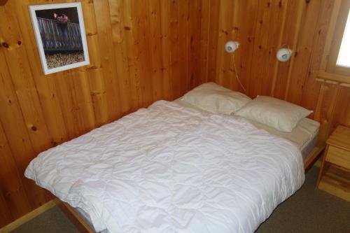 a bed in a room with a wooden wall at Fontannets 003 MOUNTAIN & QUIET chalet 10 pers in Salins