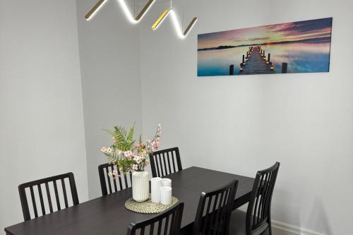 a dining room with a black table and chairs at Manchester City Oasis - Spacious 5 Bedroom House in Manchester