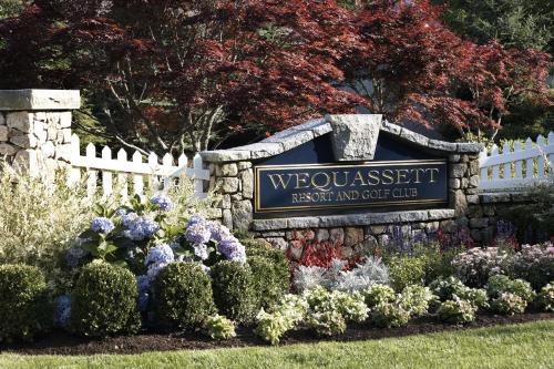 a sign for a wolcombebush resort and cottage with flowers at Wequassett Resort and Golf Club in East Harwich