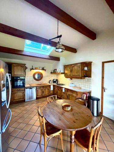 une grande cuisine avec une table et des chaises en bois dans l'établissement Authentique mas provençal Gémenos, à Gémenos