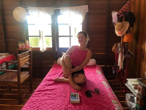 a woman sitting on a bed in a bedroom at Artist Homestay in Ko Yao Noi