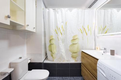 un bagno con un water e una tenda da doccia di Home2Book Cozy Coastal Duplex & Pool, Caletillas a Punta Larga