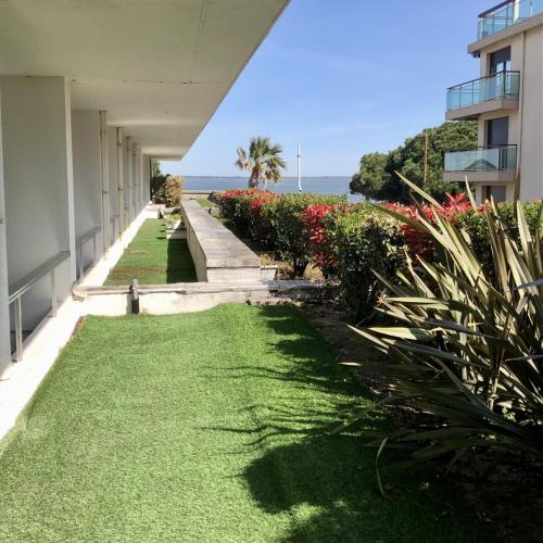 a walkway with grass and flowers next to a building at Hôtel Point France in Arcachon
