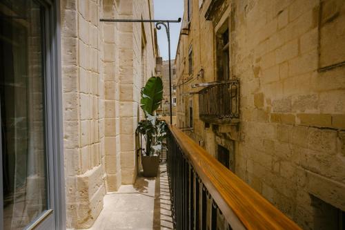 an alley with a potted plant on a balcony at IBB Hotel Palazzo Bettina Malta in Birgu