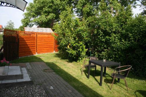 a table and chairs in a backyard with a fence at Ferienwohnungen Haus Mecklenburg in Elmenhorst