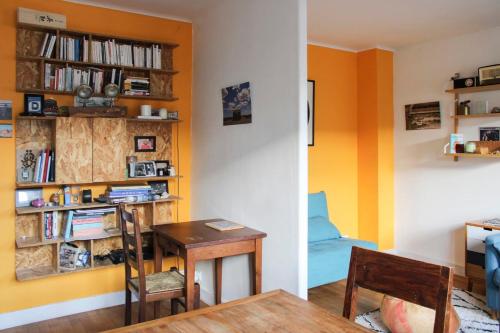 une salle à manger avec une table et une étagère à livres dans l'établissement Bright T2 just outside the City of Light, à Aubervilliers