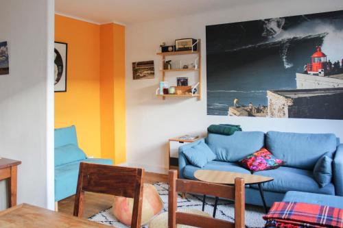 un salon avec un canapé bleu et une table dans l'établissement Bright T2 just outside the City of Light, à Aubervilliers