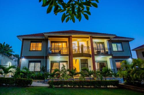 a large house with balconies and trees at Najjera Apartments in Kira