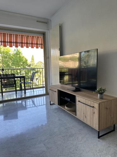 un salon avec une grande télévision à écran plat dans l'établissement Cozy flat with pool and balcony, à Antibes