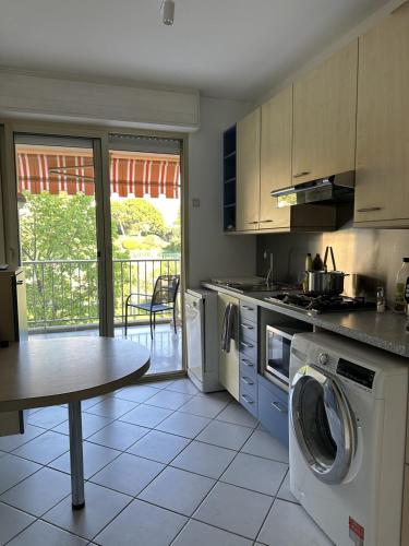 une cuisine avec lave-linge et table dans l'établissement Cozy flat with pool and balcony, à Antibes