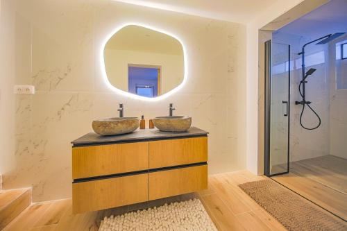 une salle de bain avec deux lavabos et un miroir dans l'établissement Casa Mia-Appartement Standing-Monticello, à Monticello