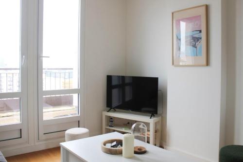 布洛涅-比扬古Superb apartment with view of Eiffel Tower的配有平板电视和桌子的客厅