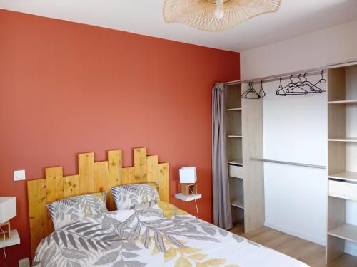 a bedroom with an orange wall and a bed at La Maison du Lividig 3 étoiles OT29 in Brignogan-Plages