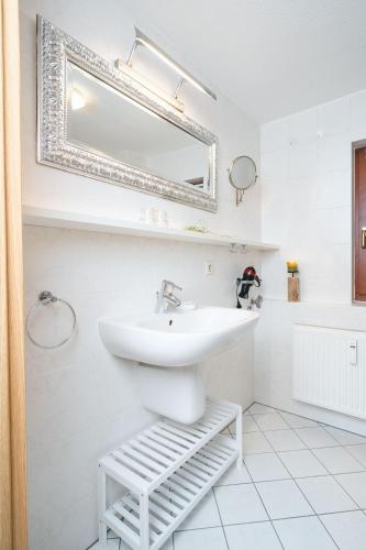 a white bathroom with a sink and a mirror at Ferienwohnungen Alte Destillerie Rathen in Rathen