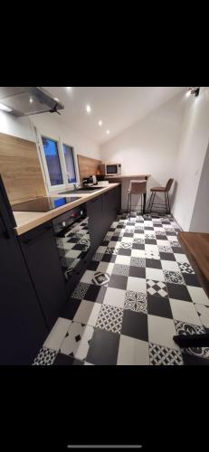 - une cuisine avec un sol en damier noir et blanc dans l'établissement Appartement 4 personne, à Fraize