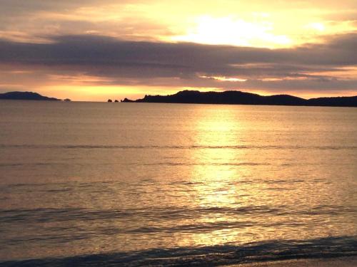 un coucher de soleil sur une étendue d'eau avec des montagnes en arrière-plan dans l'établissement L Annexe des Sables, à Hyères