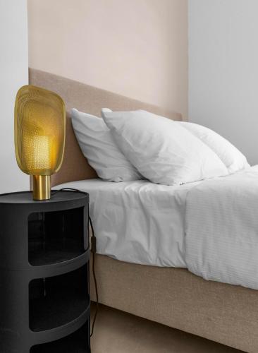 a bed with white sheets and a lamp on a night stand at Casa Blue Marlin (begane grond) in Kralendijk